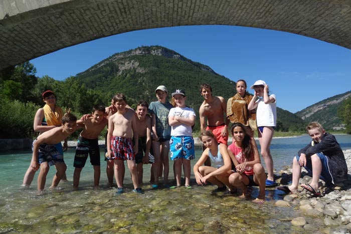 Les enfants en maillots de bain sur le lac en dessous d'un pont
